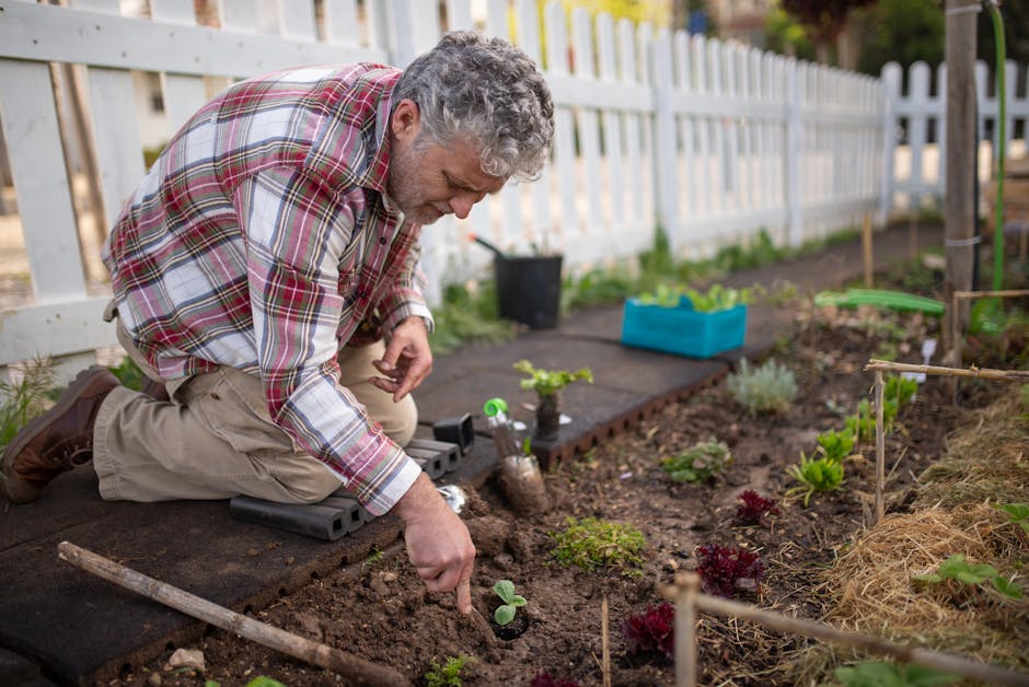Elderly gardener kneeling to plant in a vibrant garden surrounded by tools and greenery